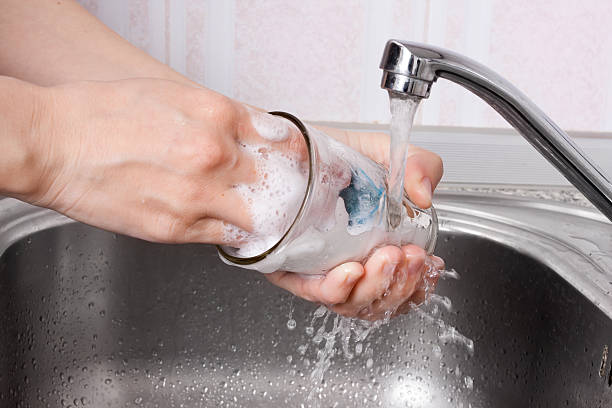 manos lavando vasos con espuma